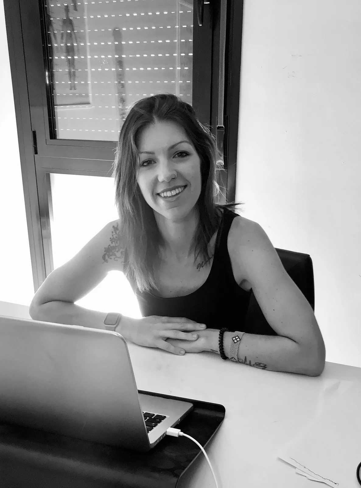 Sylvia sonriendo en su mesa de trabajo